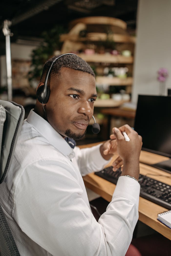 Focused customer support agent working at desk with headset and computer.